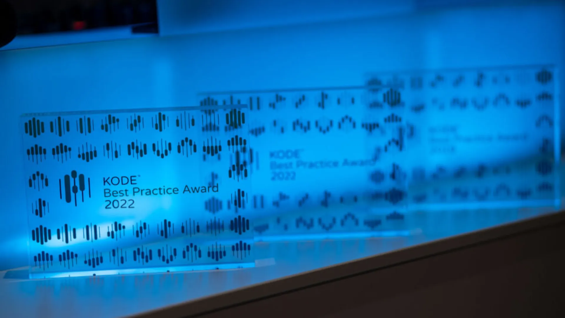 Blau beleuchtete Glaspokale des KODE® Best Practice Award 2022