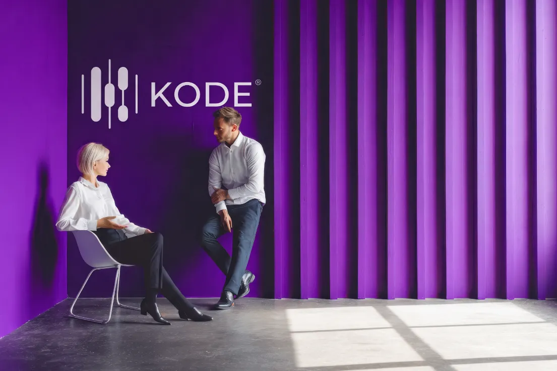 Zwei Personen im Gespräch vor der violetten KODE® Wand